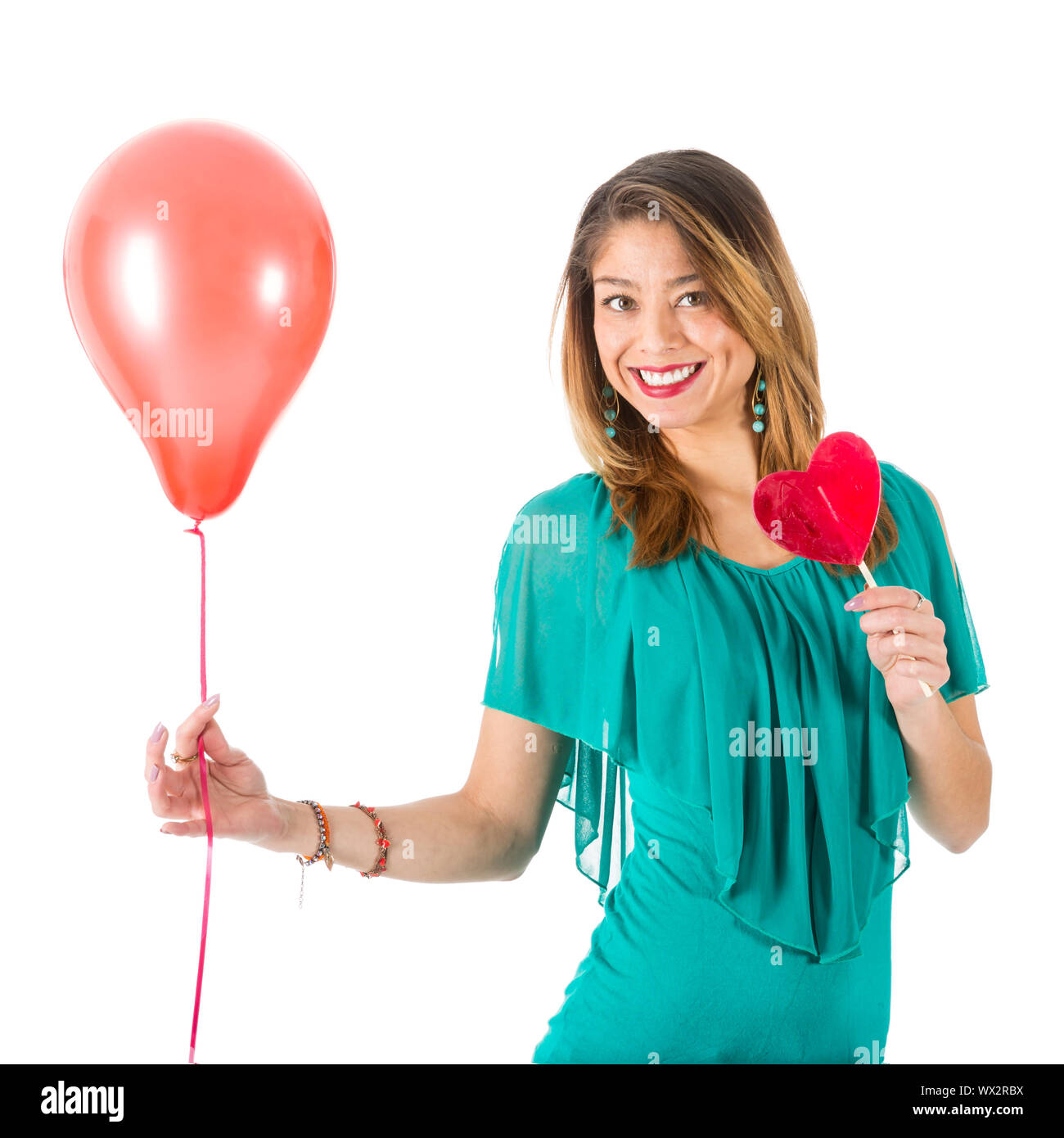 Bella donna azienda palloncino rosso e a forma di cuore lecca-lecca di fronte a lei Foto Stock