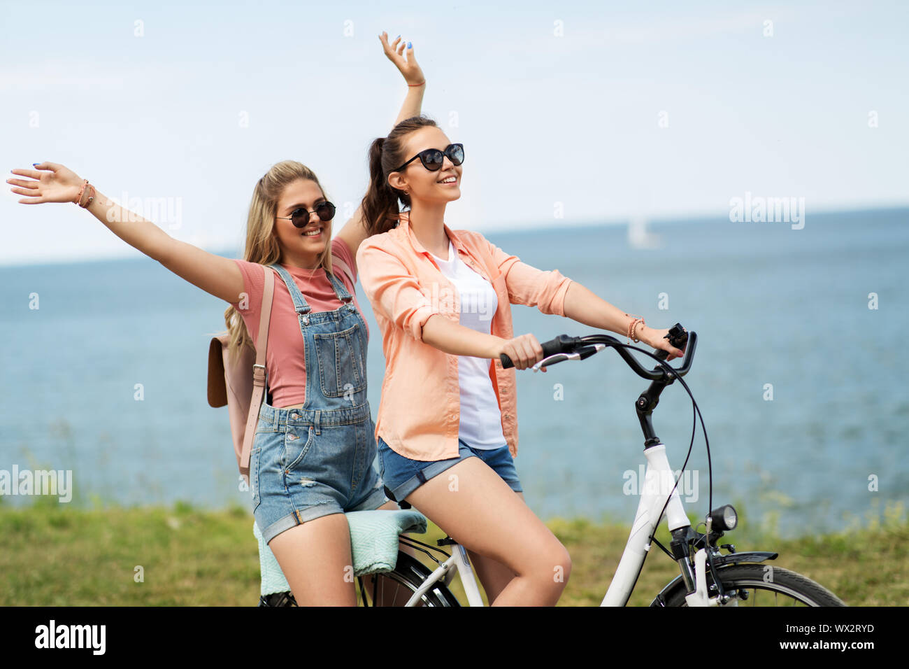 Le ragazze adolescenti o amici Bicicletta Equitazione in estate Foto Stock