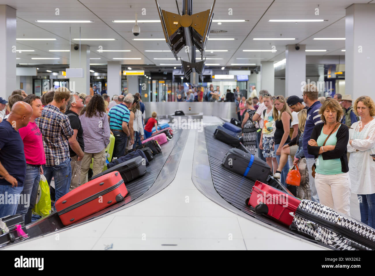 In aereo i viaggiatori in attesa per i loro bagagli all'aeroporto di Schiphol ad Amsterdam, Paesi Bassi Foto Stock