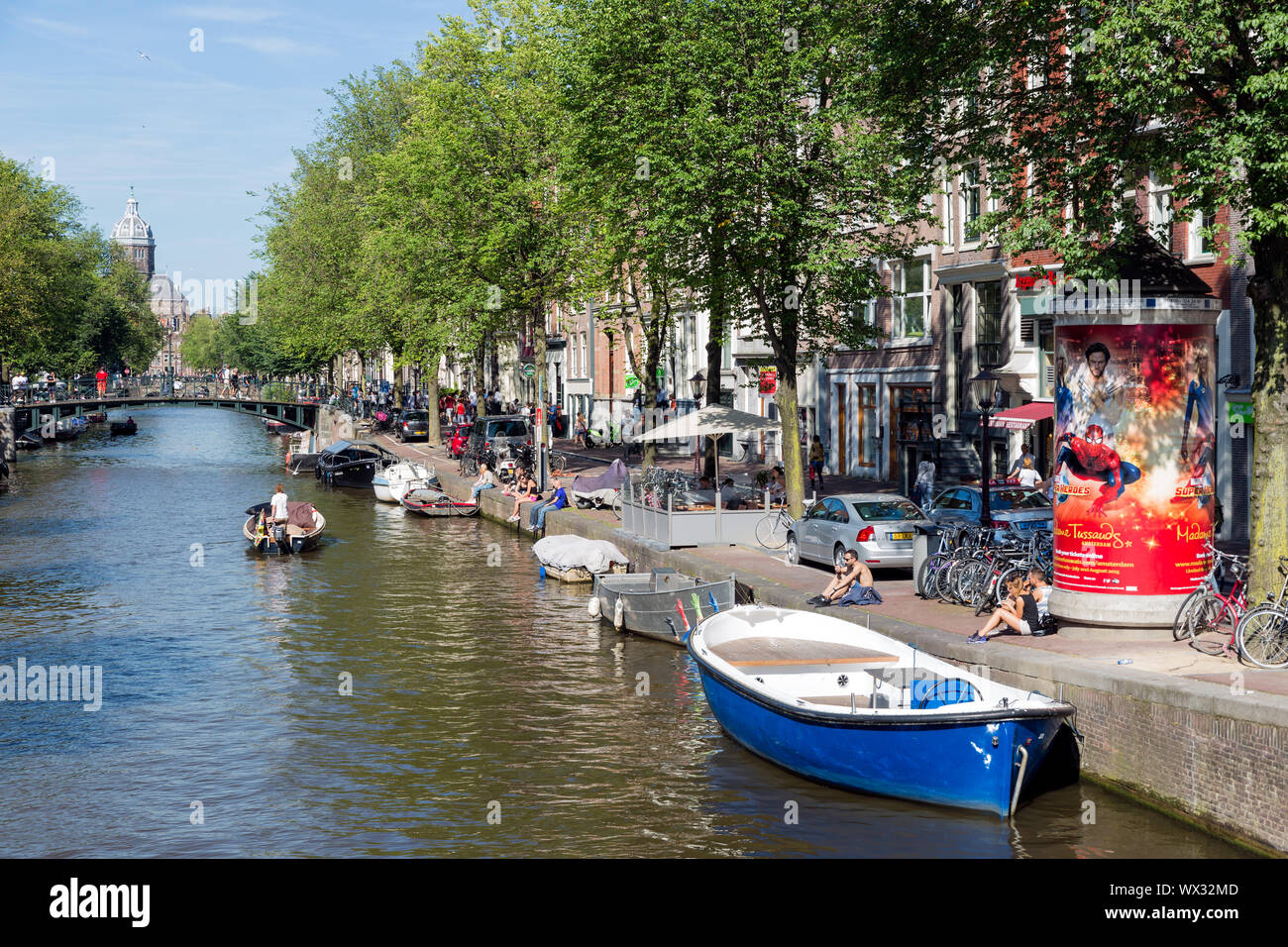 Piccole imbarcazioni in canal con palazzi storici di Amsterdam Foto Stock