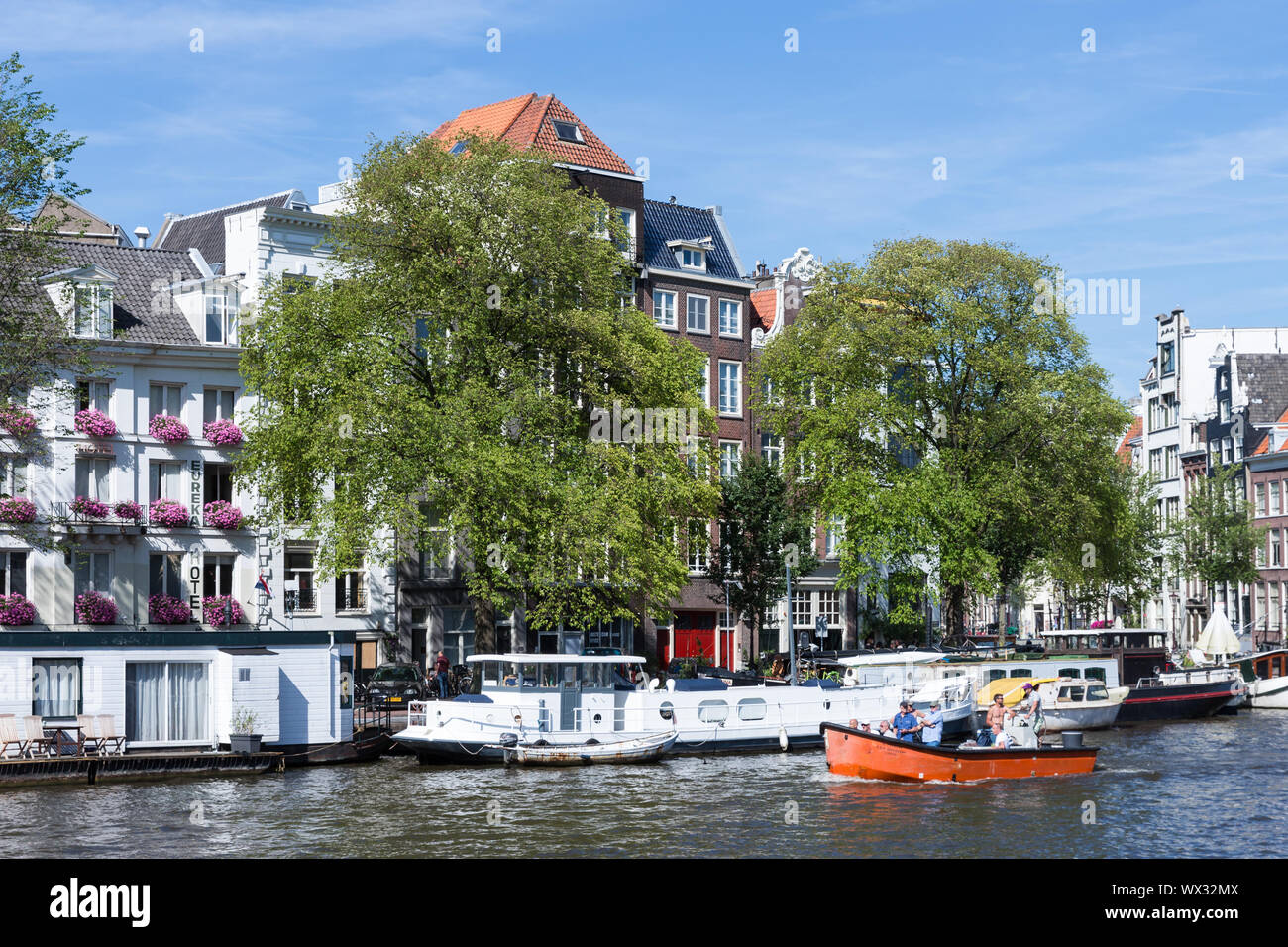 Piccola imbarcazione con persone rilassante nel canale di Amsterdam Foto Stock