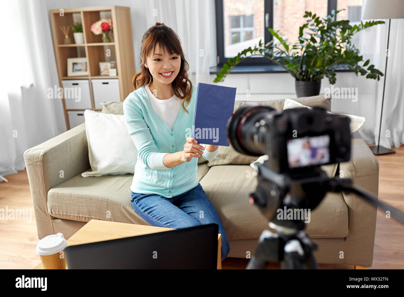 Femmina asiatica blogger rendendo video recensione del libro Foto Stock
