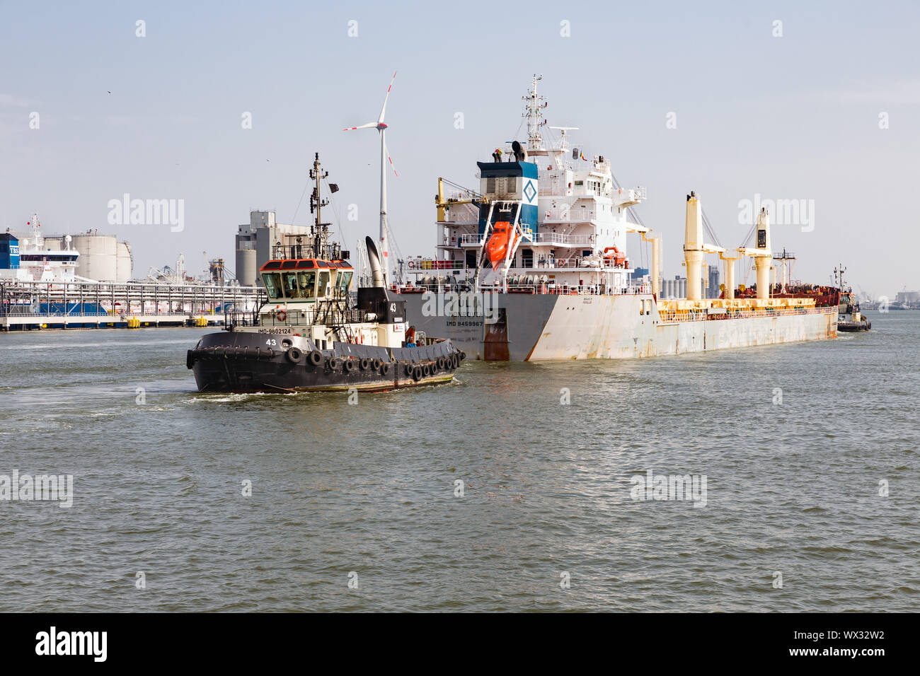 Rimorchiatore a traino con nave da carico nel porto di Anversa, Belgio Foto Stock