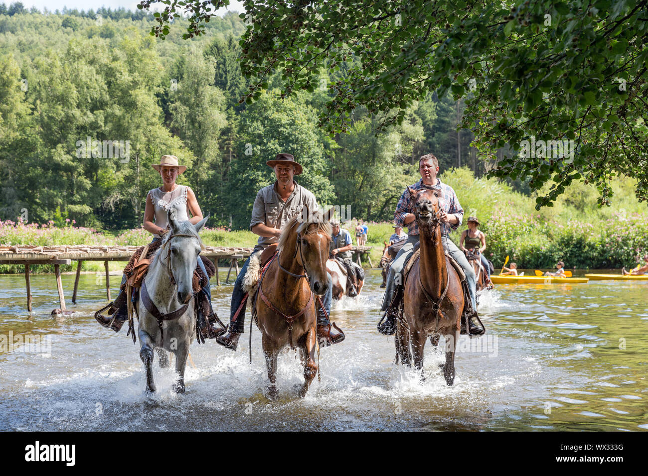 Cavalieri e cavalli che attraversano il fiume Semois vicino Laferet, Belgio Foto Stock