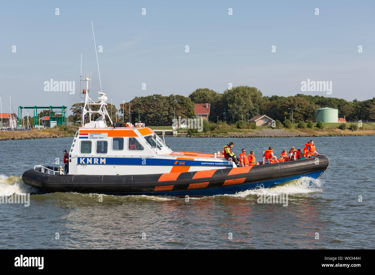 Persone che fanno la gita in barca a scialuppa di salvataggio di dimostrazione nel porto olandese Foto Stock