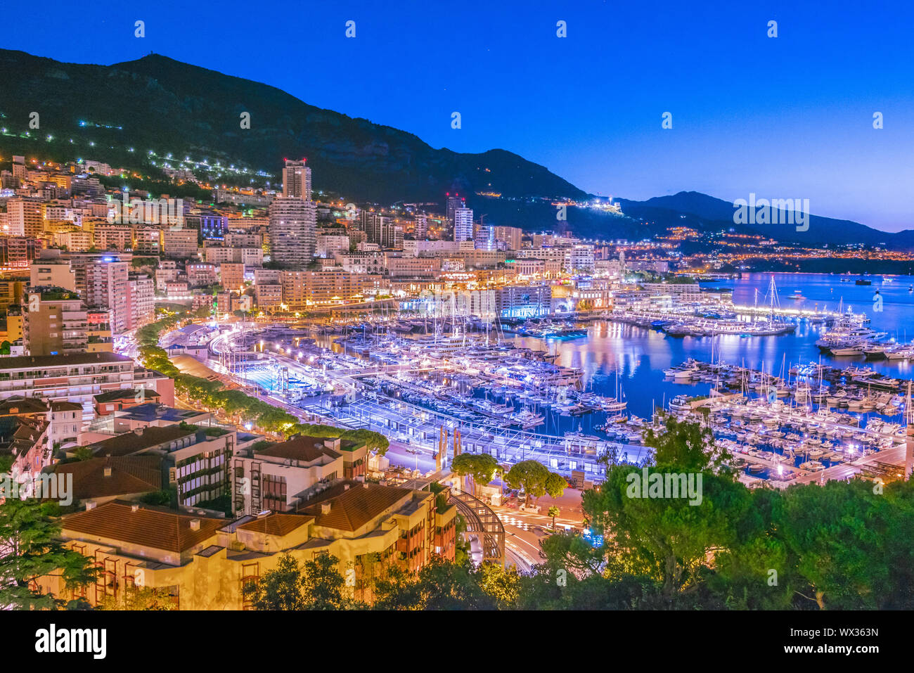 Vista della città di Monaco sulla Riviera francese dopo il tramonto. Foto Stock