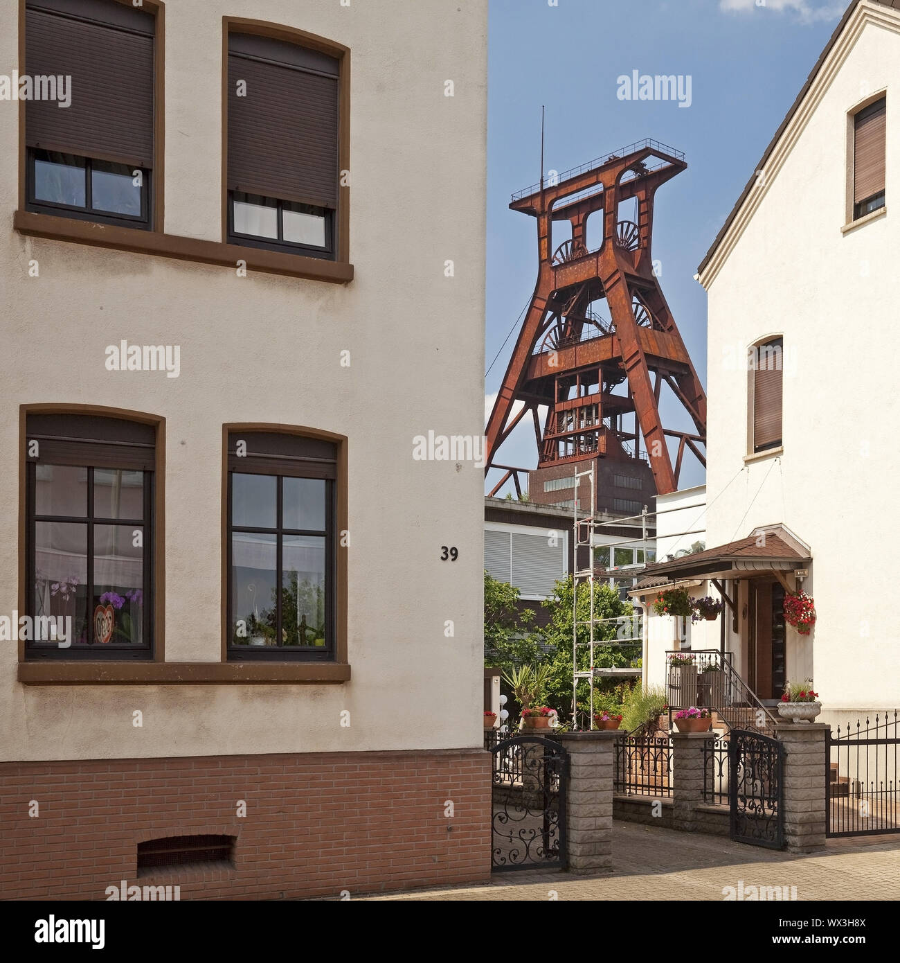 Edifici residenziali con la torre di avvolgimento di Plutone colliery, Herne, la zona della Ruhr, Germania, Europa Foto Stock
