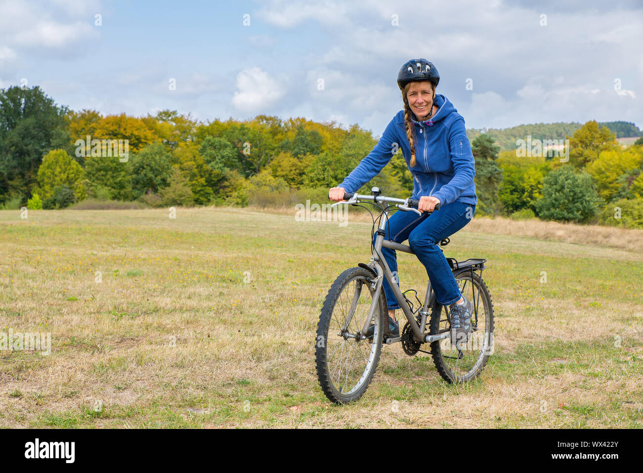 Donna europea ciclismo in mountain bike nella natura Foto Stock