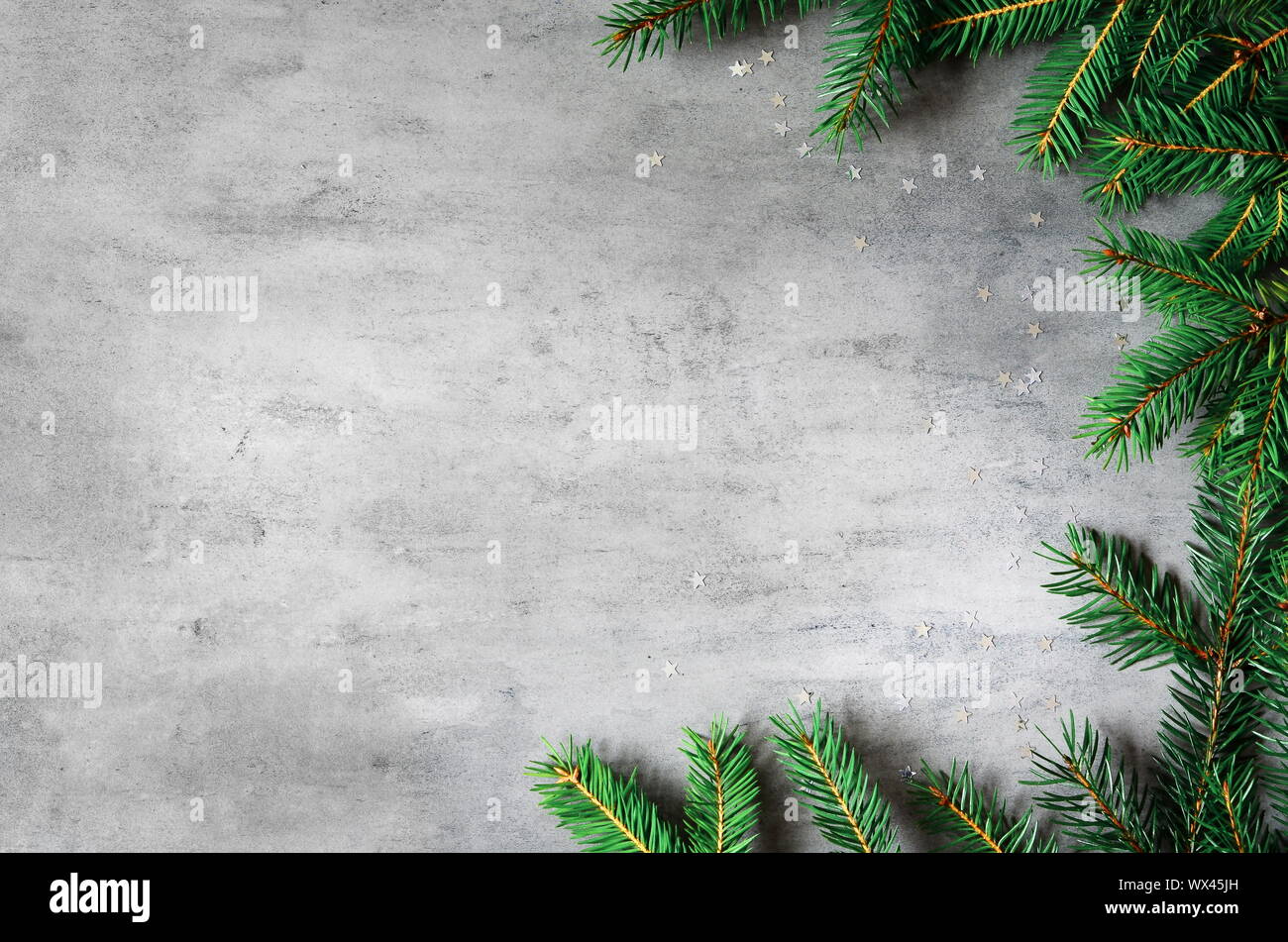 Rami di abete sulla frontiera, sfondo grigio Sfondo di natale. Foto Stock
