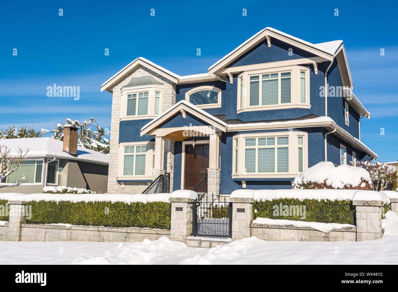 Di lusso casa residenziale con cortile anteriore nella neve in inverno giornata di sole Foto Stock