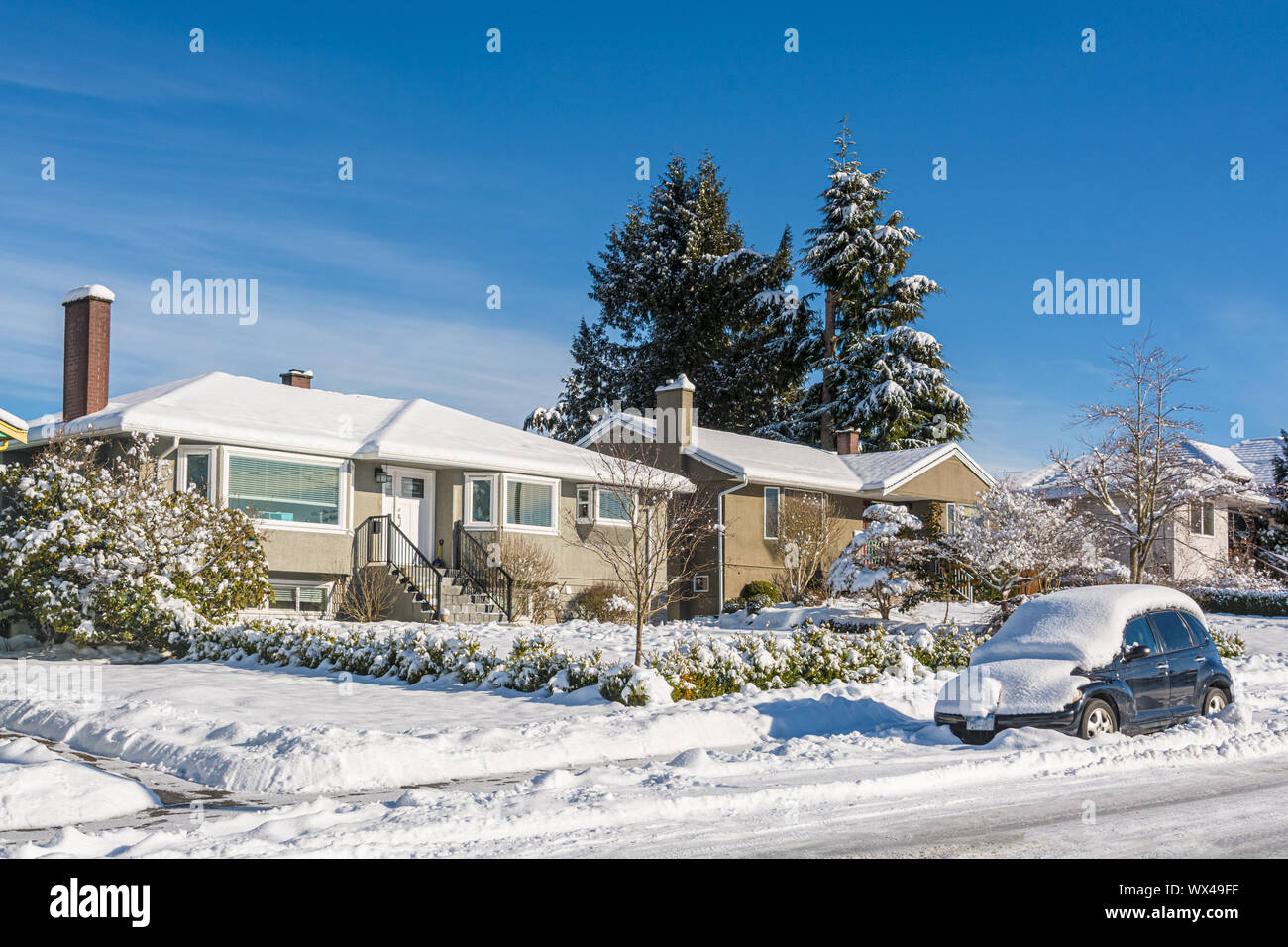 Coperta di neve casa residenziale con auto nella neve sulla strada Foto Stock