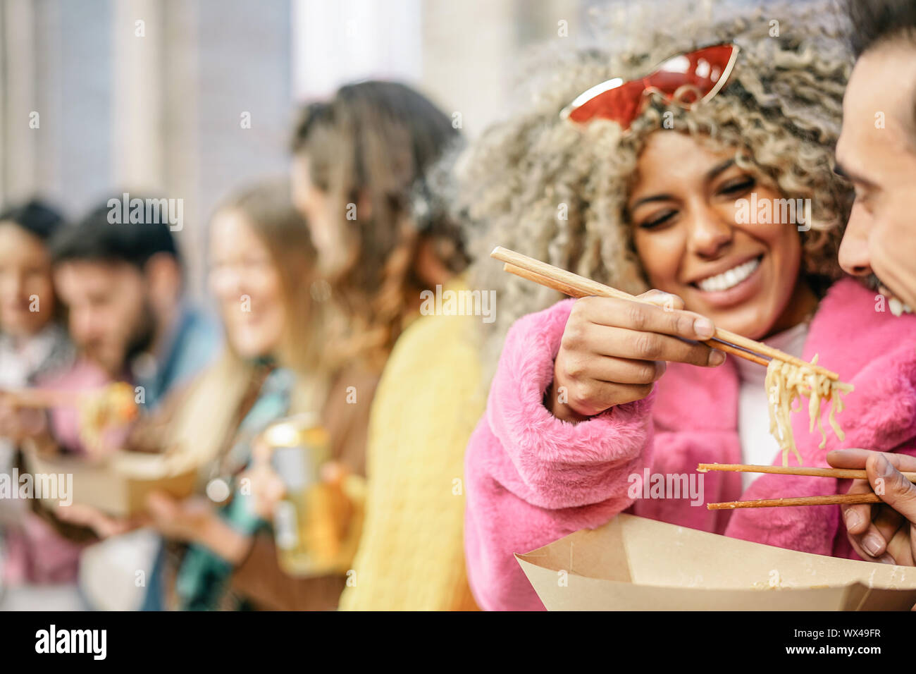 Gruppo di happy amici asiatici mangiare cibo di strada all'aperto - giovani persone alla moda per divertirsi facendo un pasto veloce insieme nella città Foto Stock