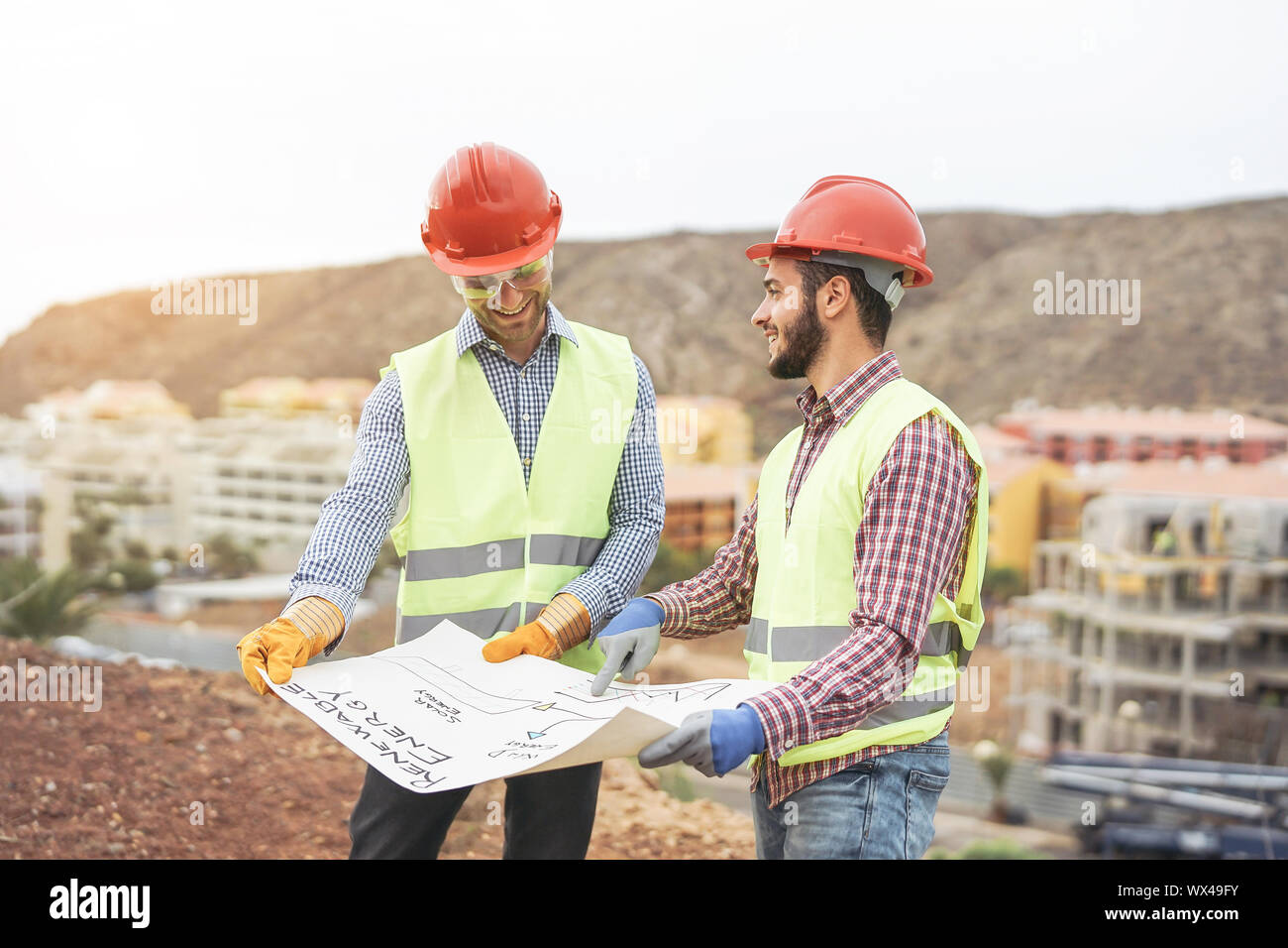 Gli ingegneri di lavoratori per discutere circa il nuovo edificio area - Giovani costruttori la lettura del progetto nel sito in costruzione Foto Stock