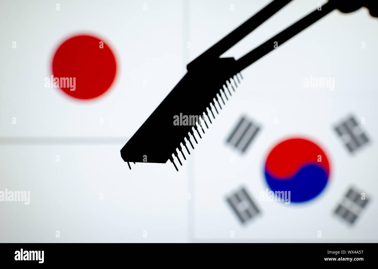 Silhouette di un chip a semiconduttore tenere in bacchette e bandiere di Giappone e Corea del Sud su un schermo sfocata. Foto concettuale per la guerra commerciale. Foto Stock