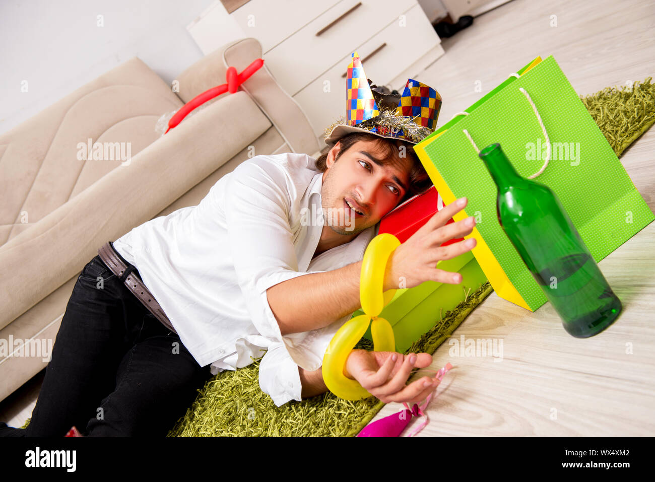 Giovane uomo avente i postumi della sbornia dopo essere partito Foto Stock