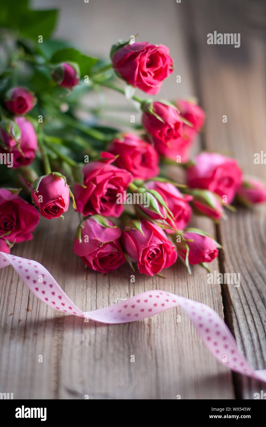 Le rose rosa su una tavola di legno Foto Stock