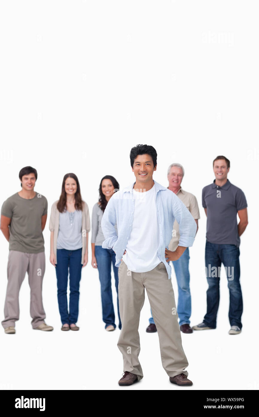 Uomo con le mani sul suo hip e amici dietro di lui Foto Stock