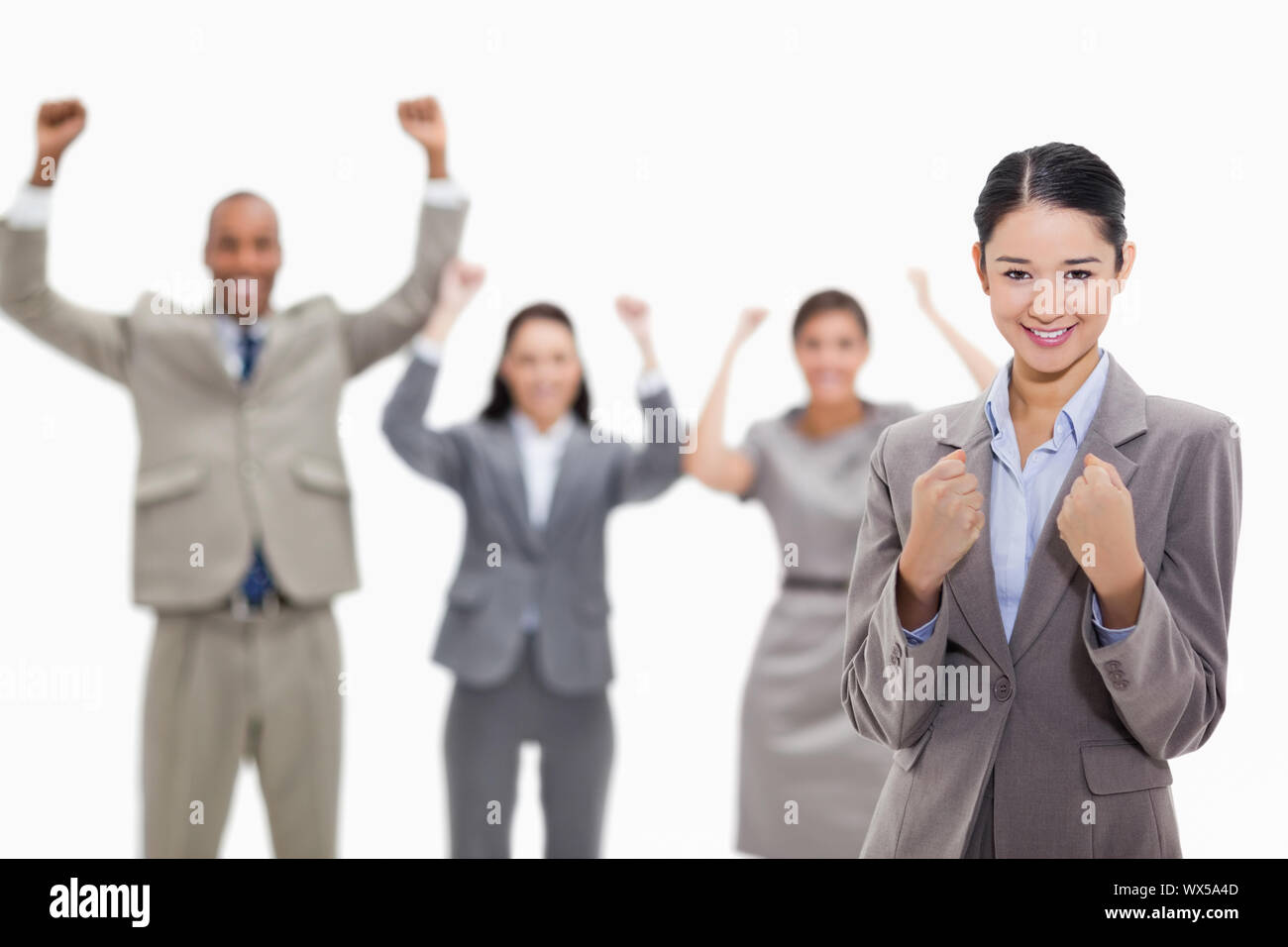 Close-up di una imprenditrice sorridente e stringendo i suoi pugni con entusiasmo co-lavoratori in background Foto Stock