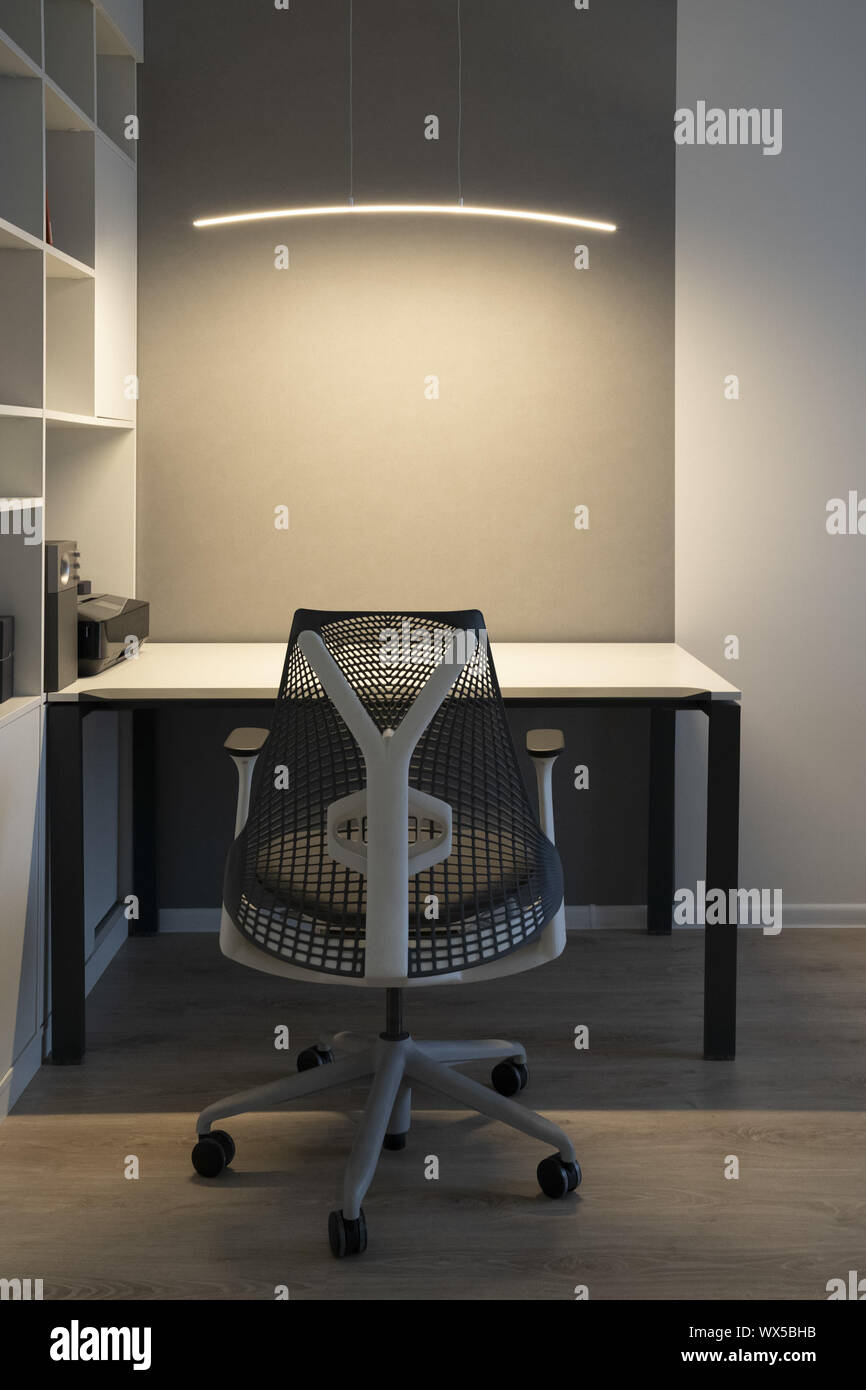 Ufficio moderno luogo con una confortevole area di lavoro di Office - desk computer, sedia ortopedica e a destra la luce artificiale per il lavoro. Foto Stock