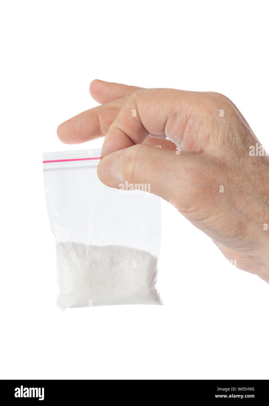 La mano e il pacchetto con le sostanze stupefacenti Foto Stock
