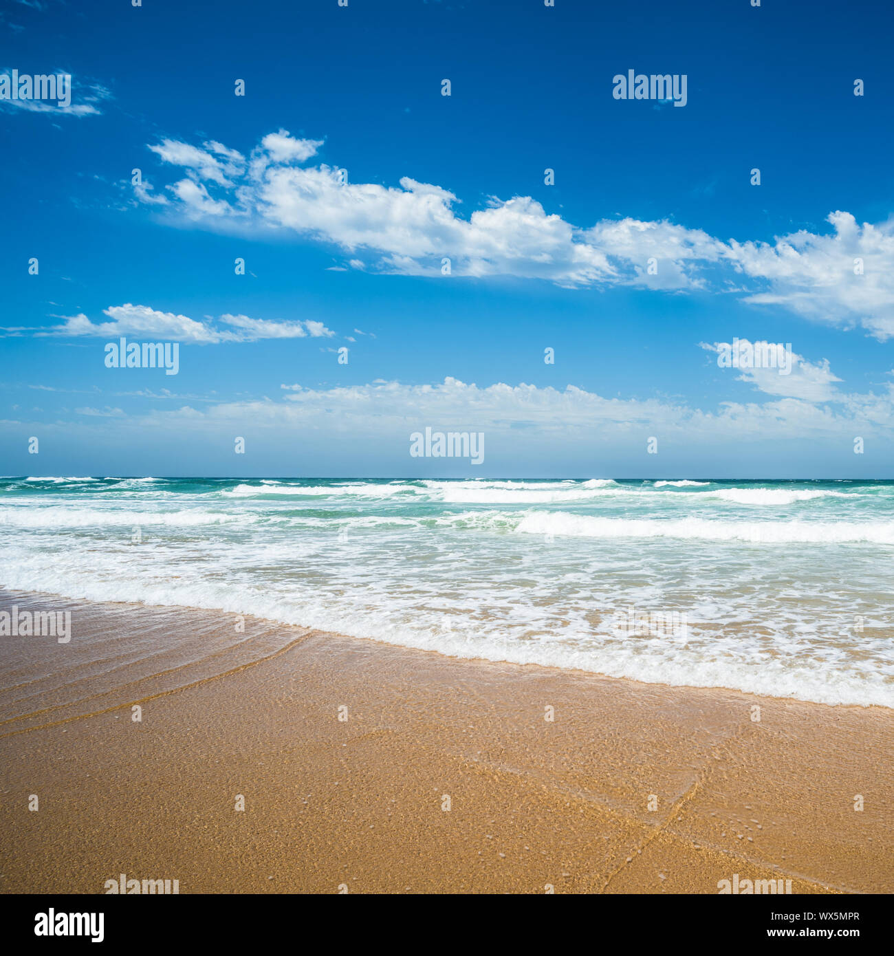 Giallo sabbia spiaggia, il mare e il profondo blu del cielo. Foto Stock