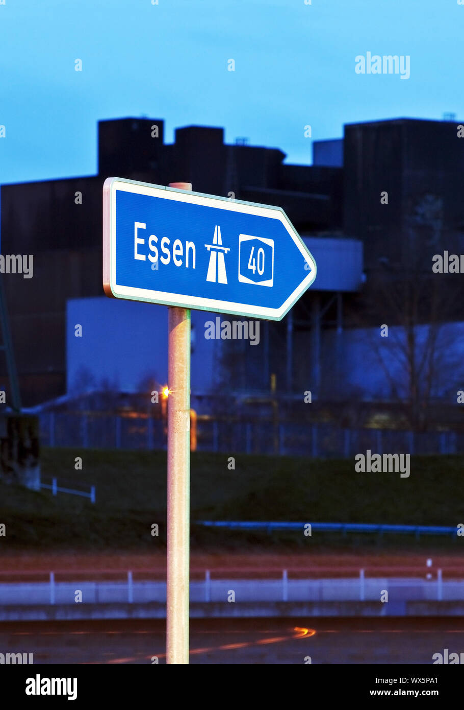 Segno di direzione di Essen sull'autostrada A40 in serata, Bochum, la zona della Ruhr, Germania, Europa Foto Stock