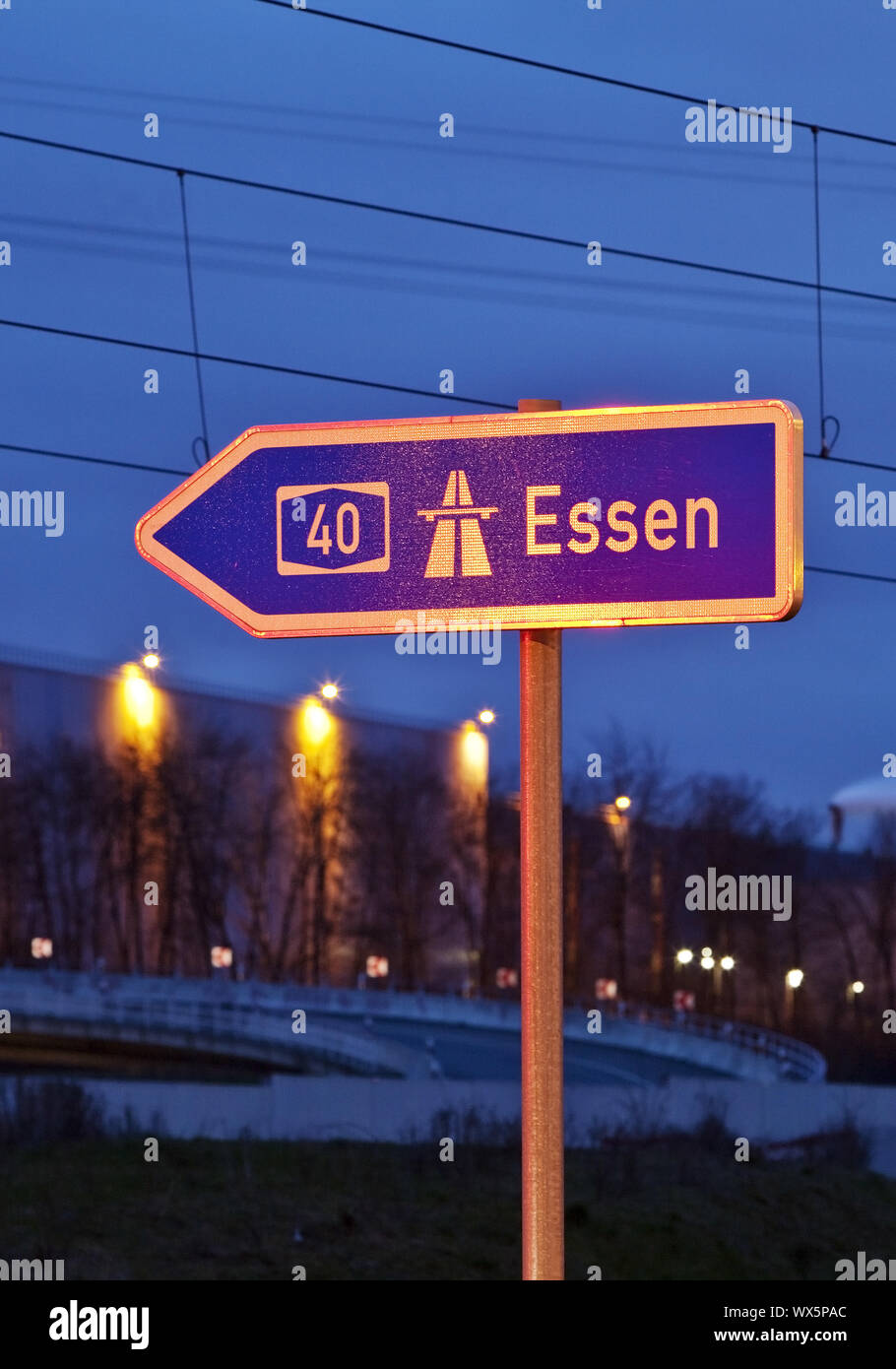Segno di direzione di Essen sull'autostrada A40 in serata, Bochum, la zona della Ruhr, Germania, Europa Foto Stock
