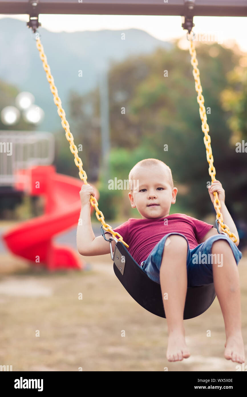 Little Boy basculante in una oscillazione Foto Stock