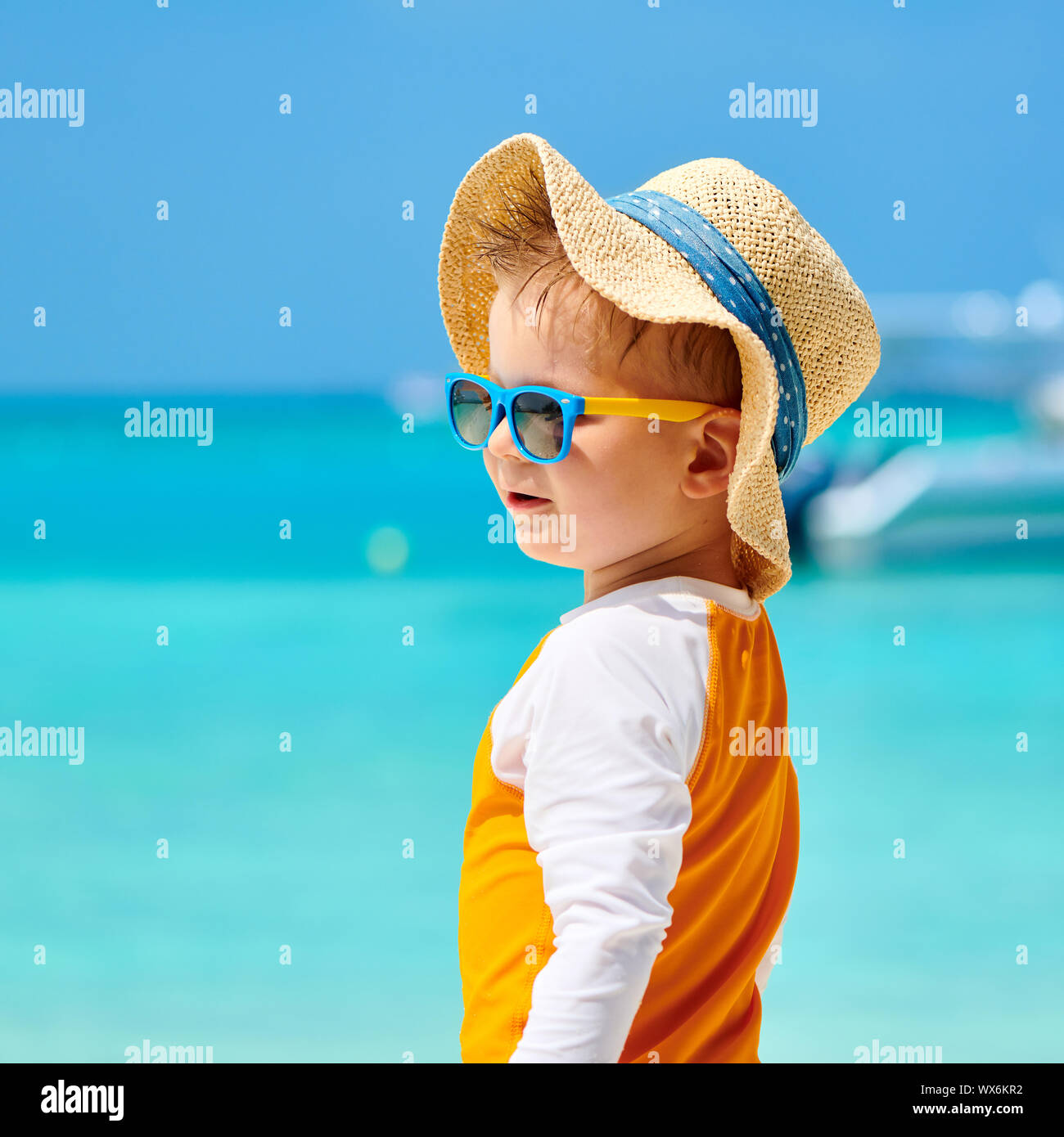 Il Toddler boy con occhiali da sole sulla spiaggia Foto Stock