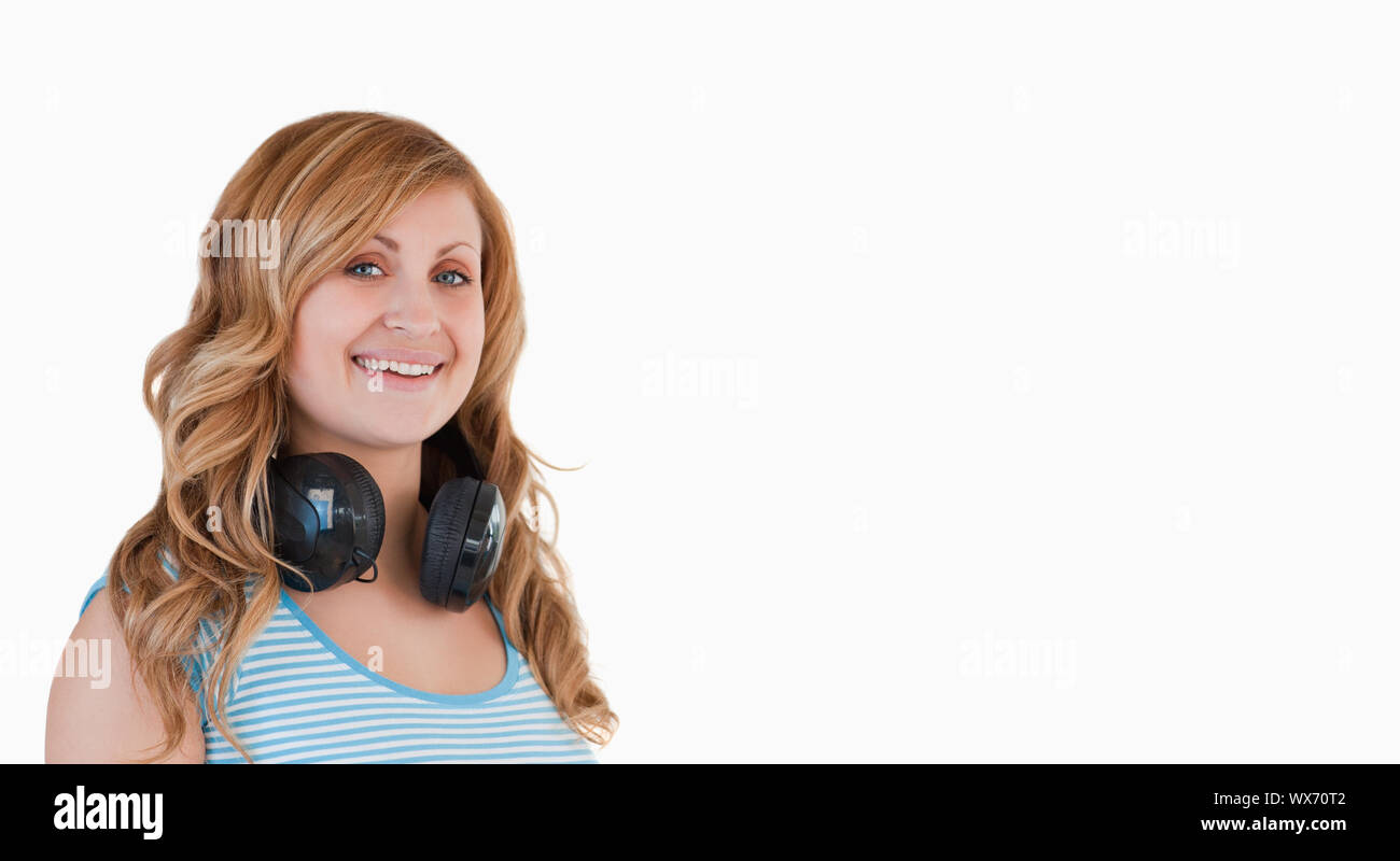 Isolato bionda donna posa con la cuffie intorno al collo Foto Stock