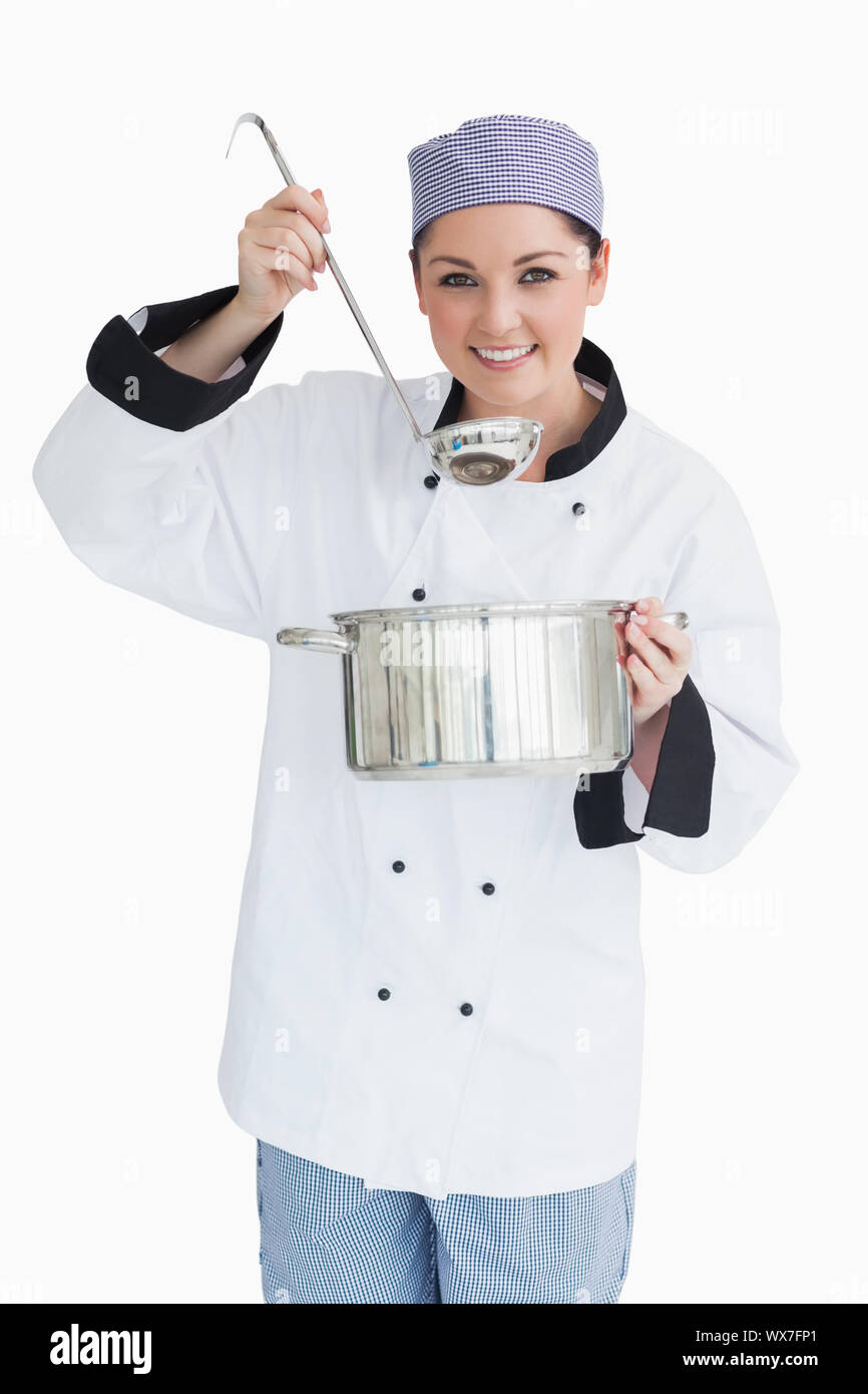 Felice cook che serve con un mestolo e una pentola nella parte anteriore della fotocamera Foto Stock