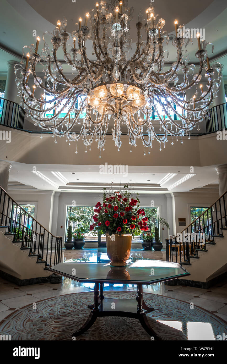 Lampadario appeso sopra la lobby con scala e sala di lusso Foto Stock