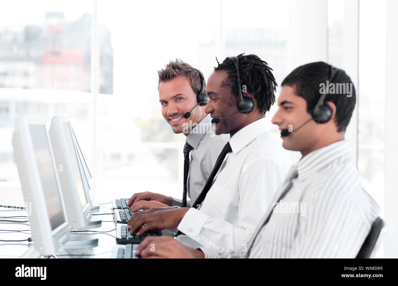 International Business team in un call center di indossare le cuffie Foto Stock