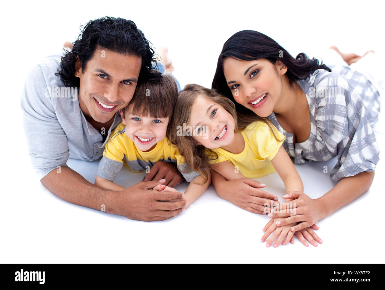 Famiglia vivace sdraiato sul pavimento contro uno sfondo bianco Foto Stock