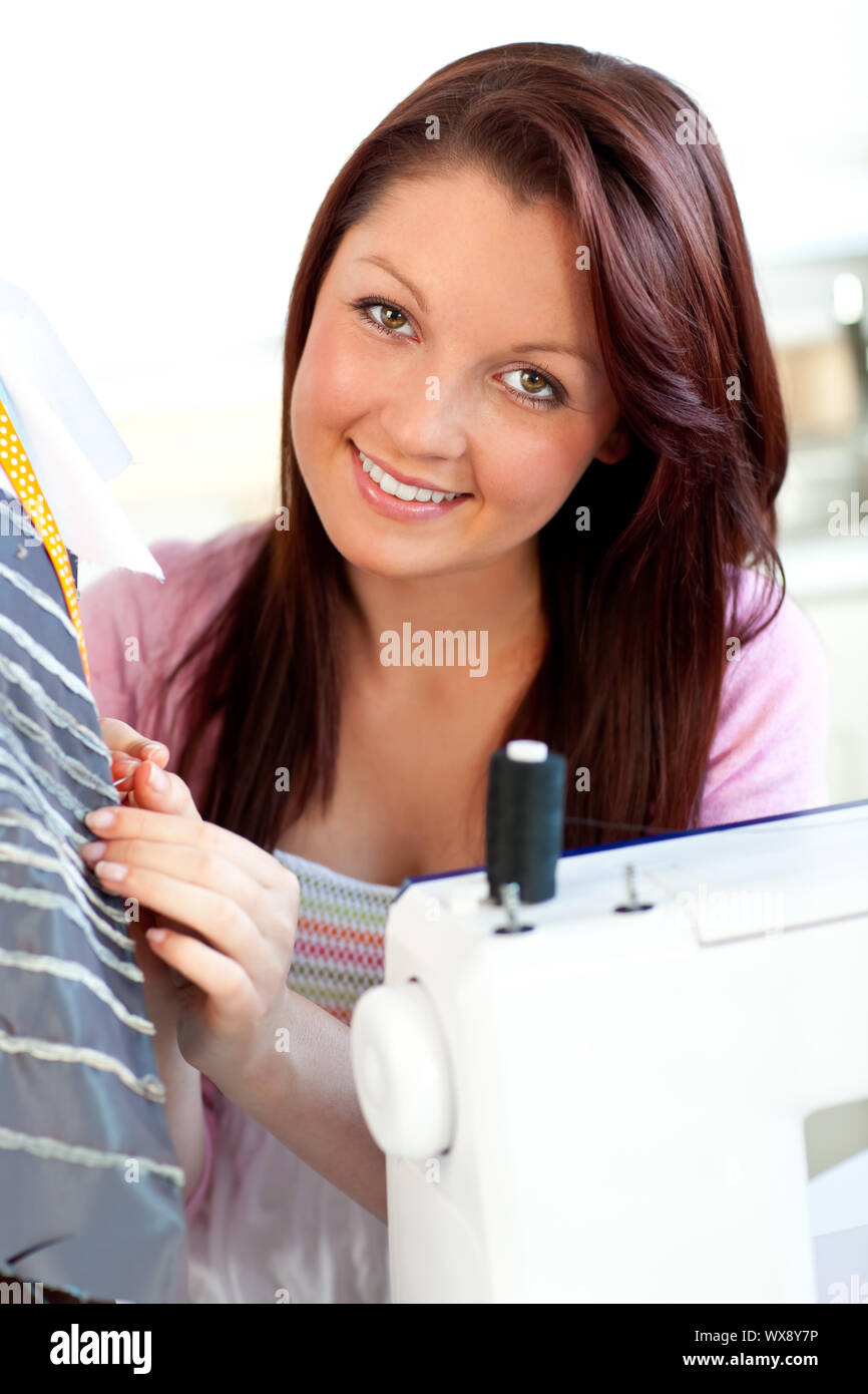 Donna attraente la cucitura a casa in cucina Foto Stock