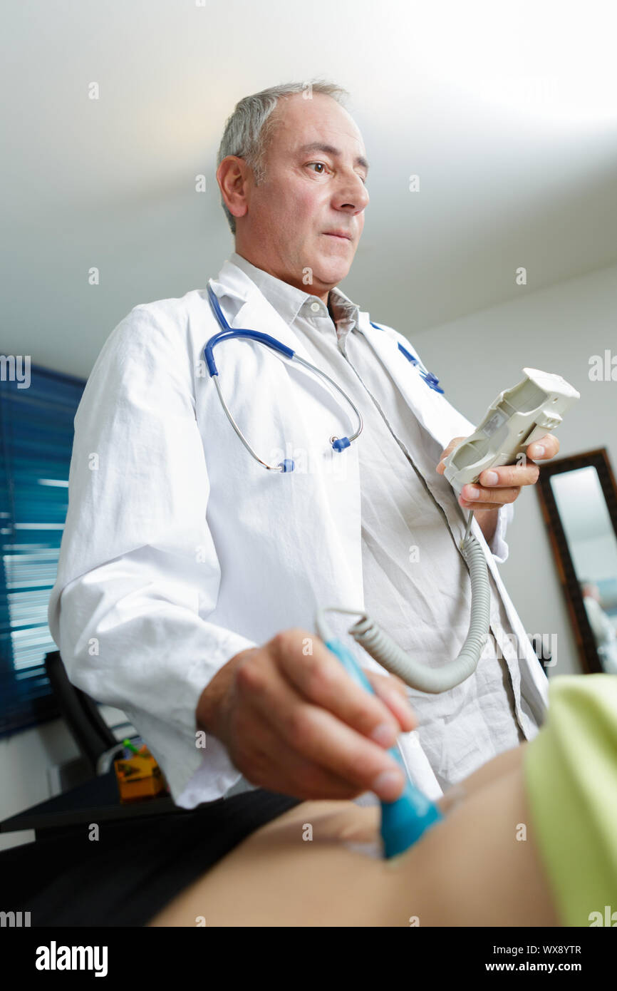 Un medico tenendo il trasduttore a ultrasuoni Foto Stock