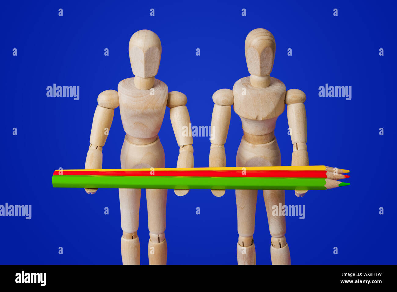 Giocattolo di legno figure con matite su blu Foto Stock