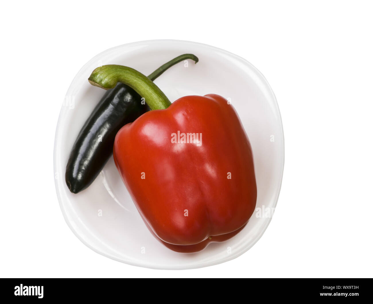 Unico jalapeno verde pepe e peperone rosso sulla piastra isolata su sfondo bianco Foto Stock