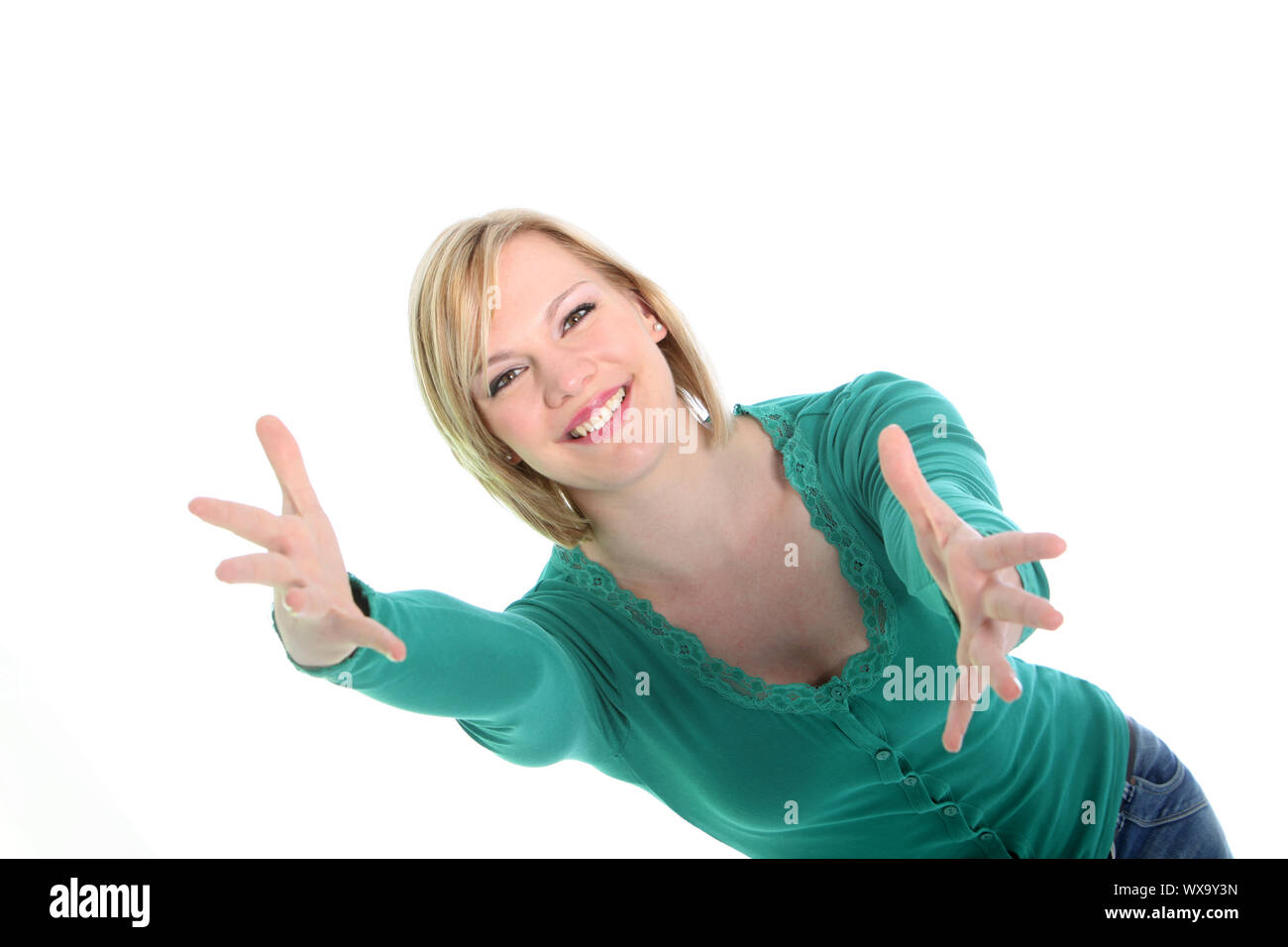 Bella sorridente giovane donna con le braccia tese in attesa di darvi il benvenuto nel suo abbraccio isolato su bianco Foto Stock