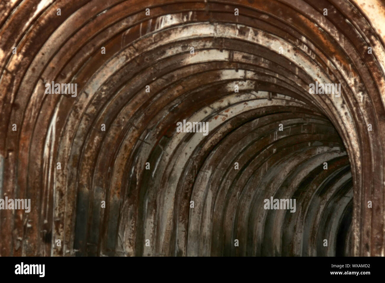 Un vecchio tunnel con un andamento arcuato travi metalliche Foto Stock