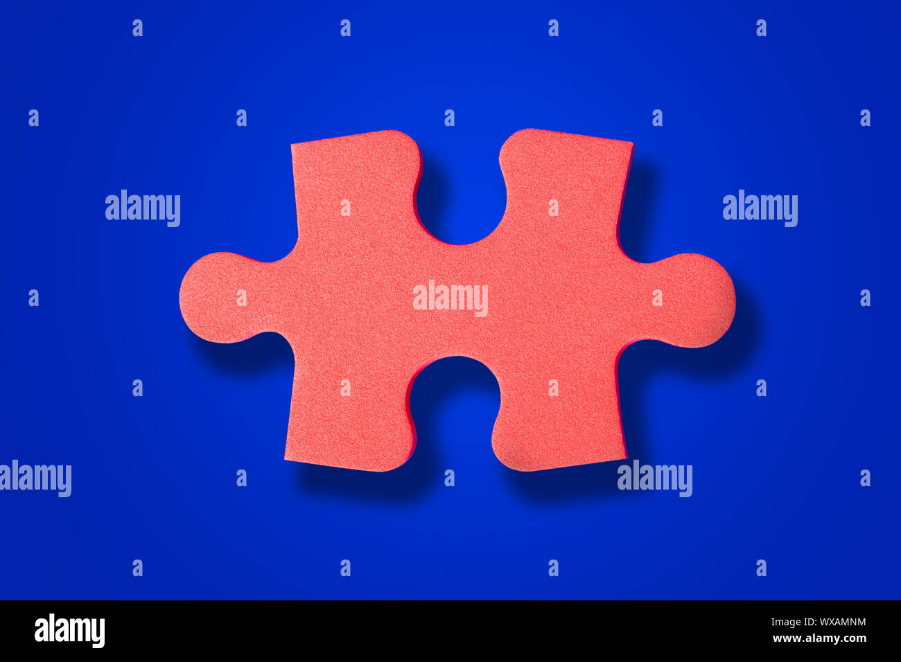 Pezzo del puzzle su blu Foto Stock