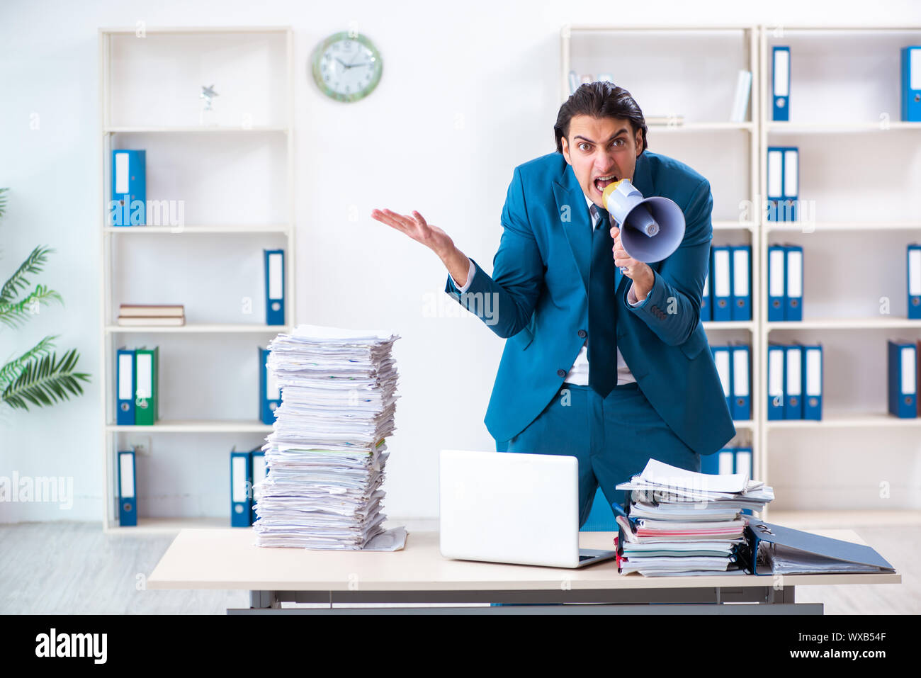 Giovane maschio dipendente scontento di un eccessivo lavoro Foto Stock