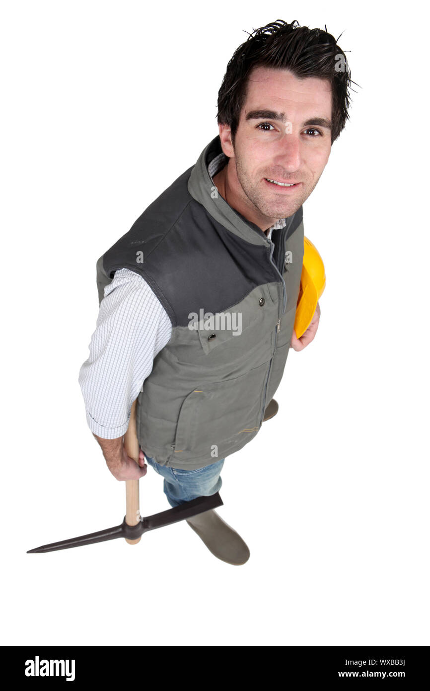 Tradesman tenendo un elmetto e un pick Foto Stock