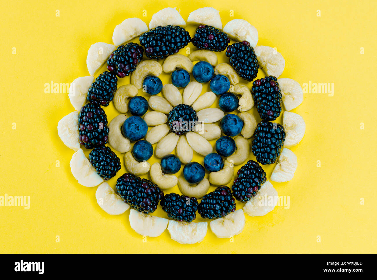 Mandala circolare disposizione delle bacche di sani frutti e i dadi Foto Stock