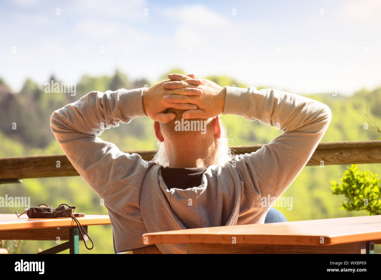 Un vecchio uomo si rilassa al sole Foto Stock
