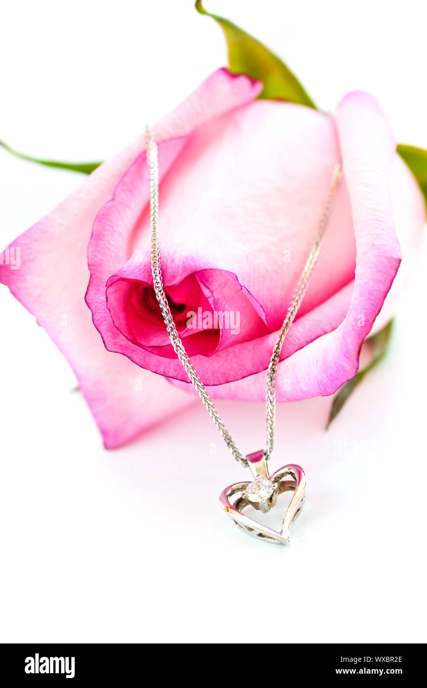 Cuore pendente con diamante con una rosa rosa Foto Stock