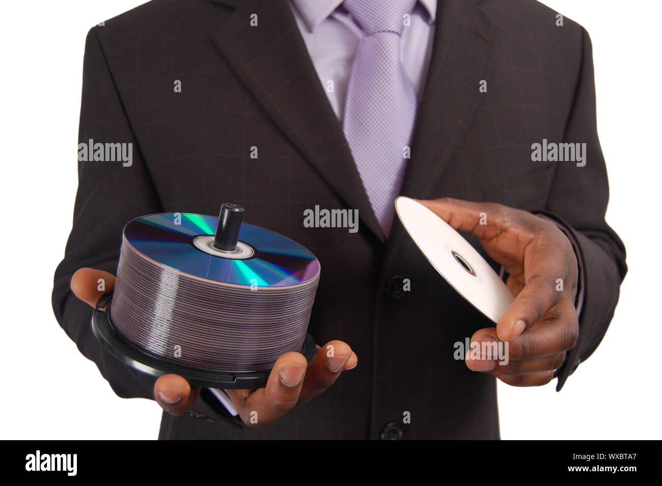 Si tratta di una immagine di un business man tenere una pila di DVD/CD. Questo può essere utilizzato per rappresentare un 'Data Service' , 'Software Backup', 'Informazioni Technol Foto Stock