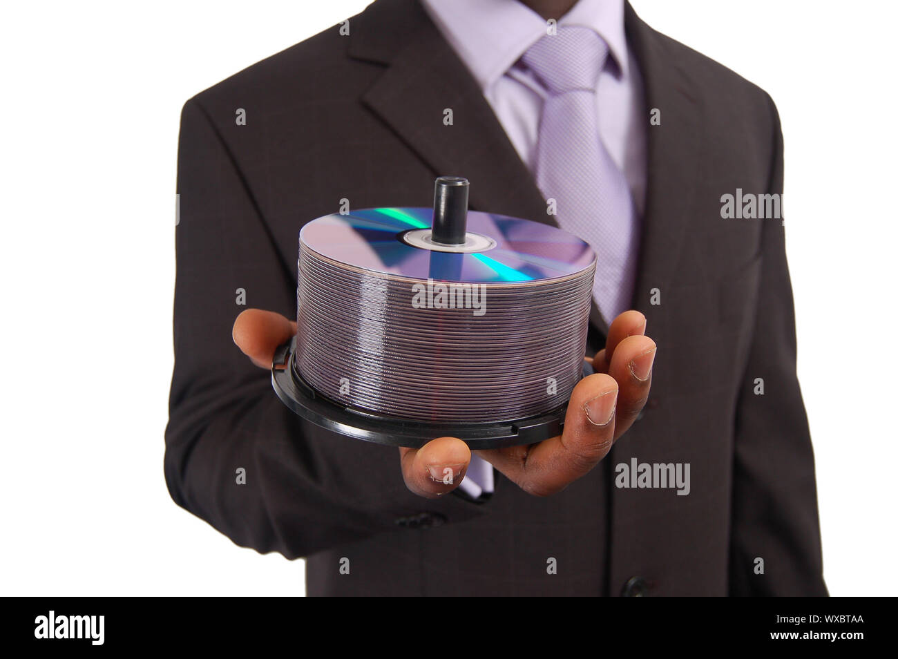 Si tratta di una immagine di un business man tenere una pila di DVD/CD. Questo può essere utilizzato per rappresentare un 'Data Service' , 'Software Backup', 'Informazioni Technol Foto Stock