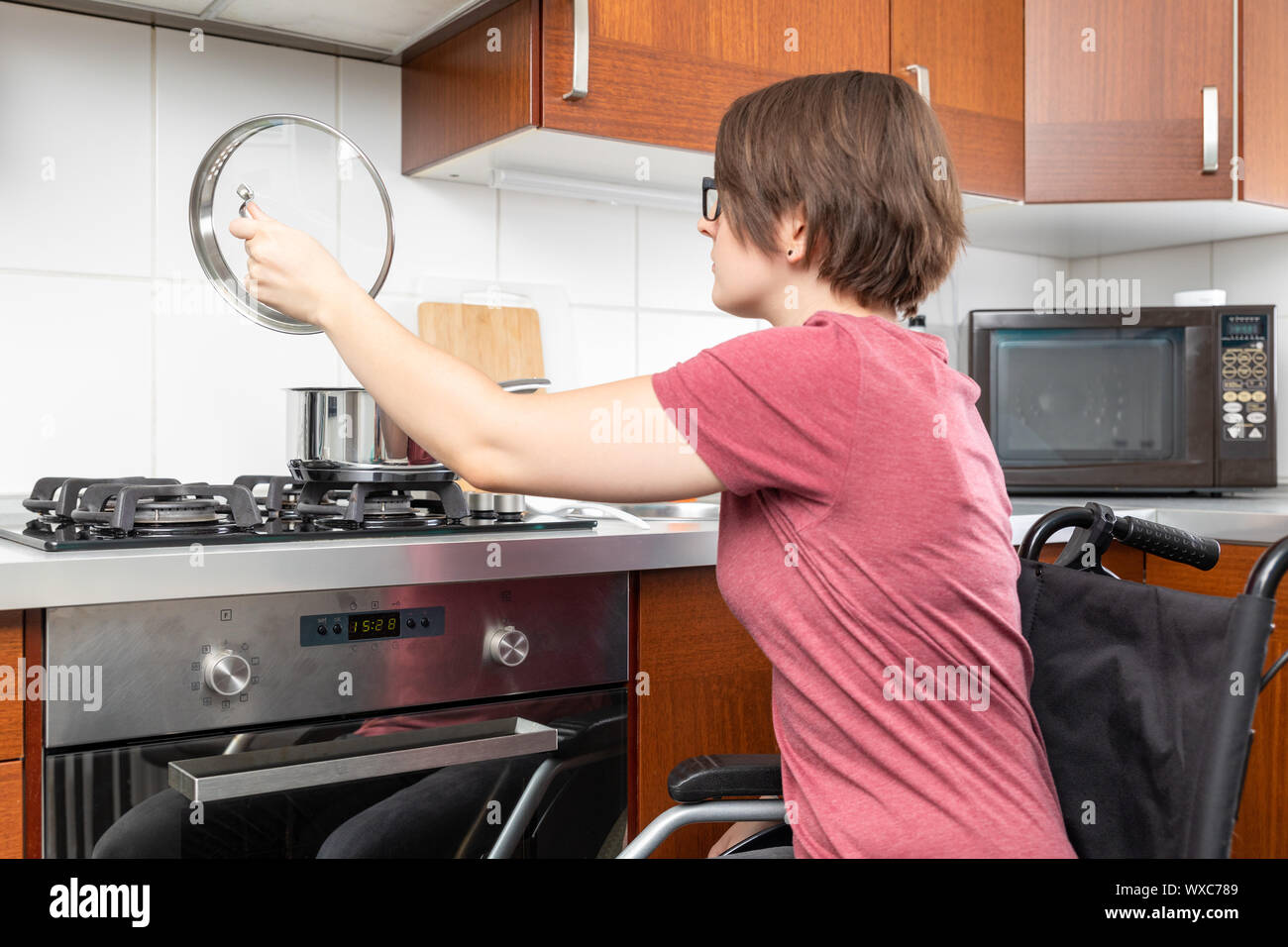 Donna disabile la cucina in cucina Foto Stock