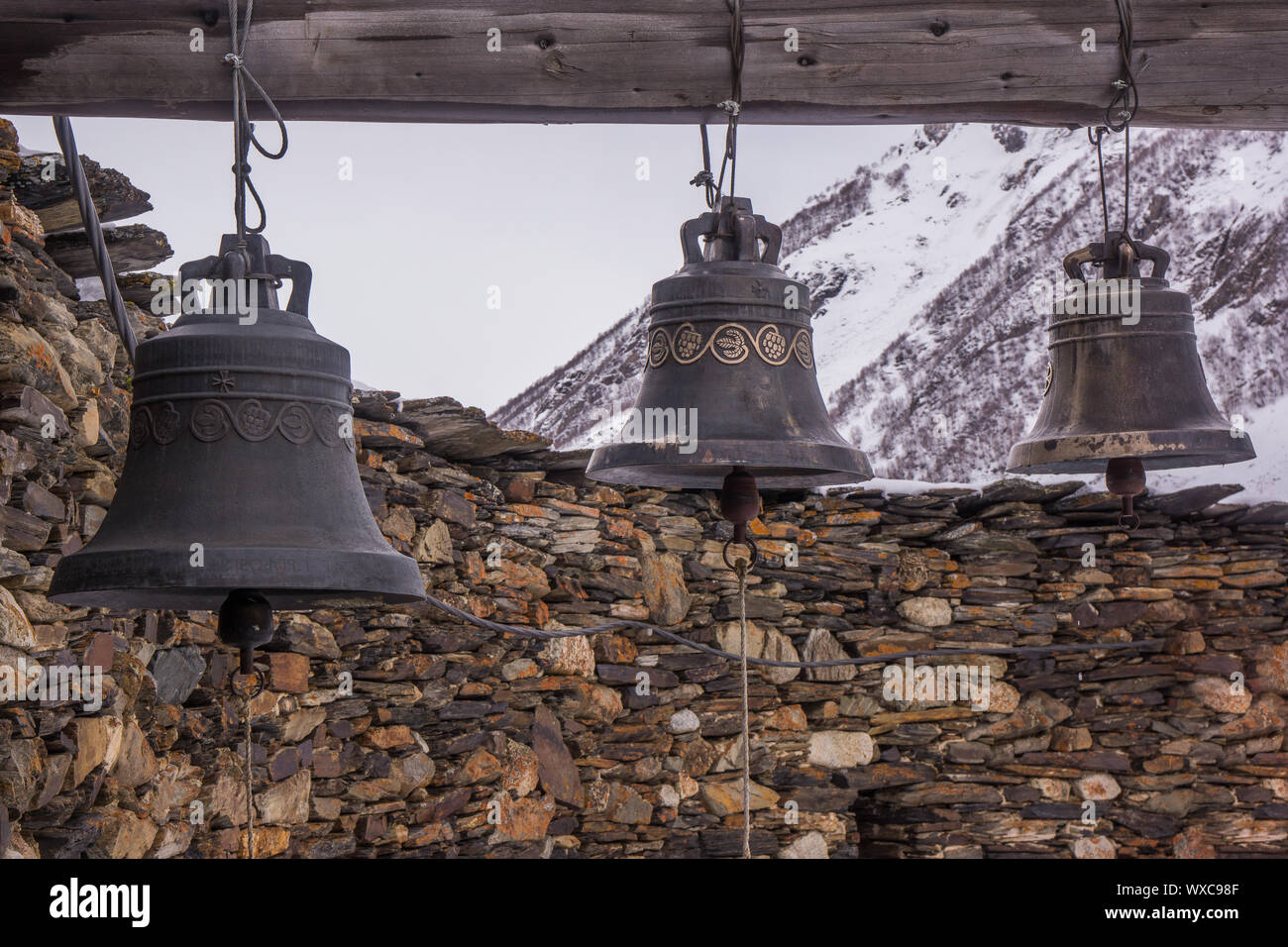 Le campane di ferro nella parte anteriore della chiesa ushguli Foto Stock